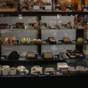 A bakery display case filled with various pastries and desserts in a retail setting.