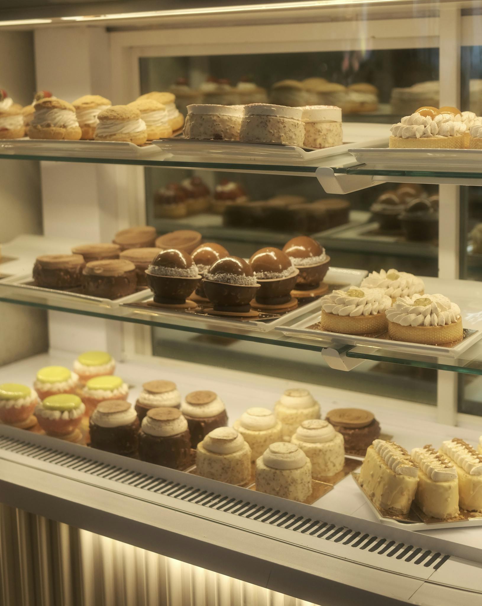 A variety of colorful pastries neatly arranged in a bakery display case.